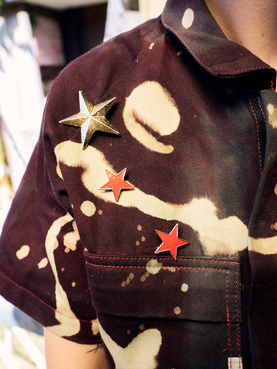 detail of star badges on planet insoird cotton dril overalls. 